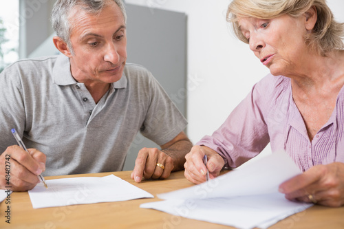 Photo: Mature couple discussing with documents Mature couple discussing with documents