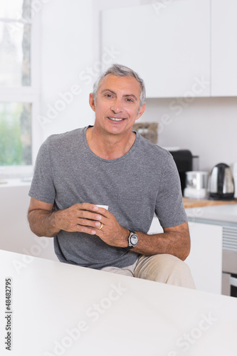 Photo: Smiling man holding a cup Smiling man holding a cup