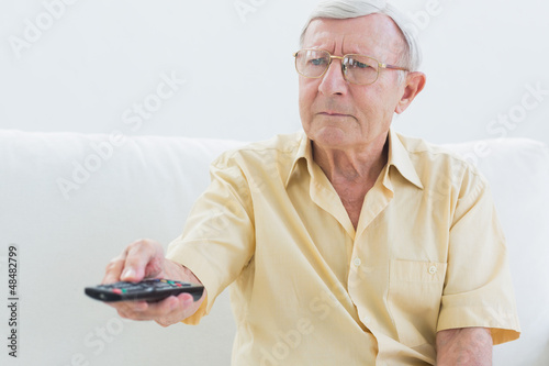 Photo: Elderly man using the remote Elderly man using the remote