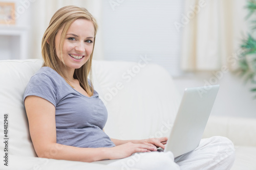 Photo: Portrait of happy casual woman using laptop at home Portrait of happy casual woman using laptop at home