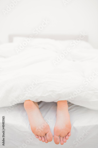 Photo: Woman's feet sticking out of blanket Woman's feet sticking out of blanket