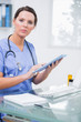 Portrait of surgeon using digital tablet at clinic