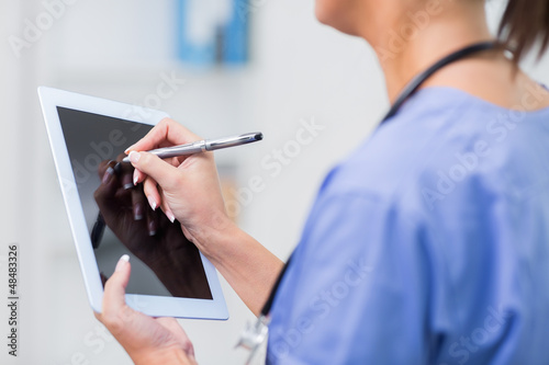 Photo: Female doctor using digital tablet Female doctor using digital tablet