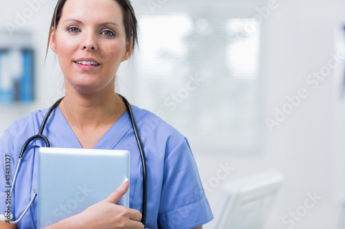 Photo: Female surgeon holding digital tablet at clinic Female surgeon holding digital tablet at clinic