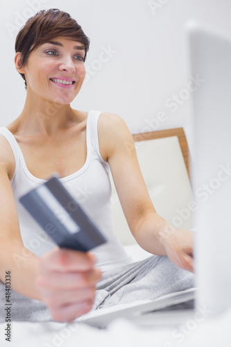 Photo: Woman shopping online in hotel room Woman shopping online in hotel room