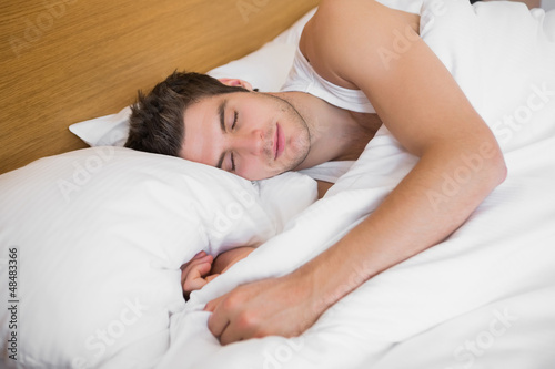 Photo: Handsome male sleeping in bed Handsome male sleeping in bed