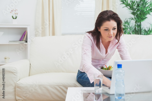 Photo: Young woman using laptop at home Young woman using laptop at home