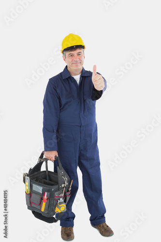 Photo: Mechanic with tool bag showing thumbs up sign Mechanic with tool bag showing thumbs up sign