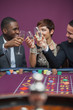 Three people celebrating in a casino with champagne