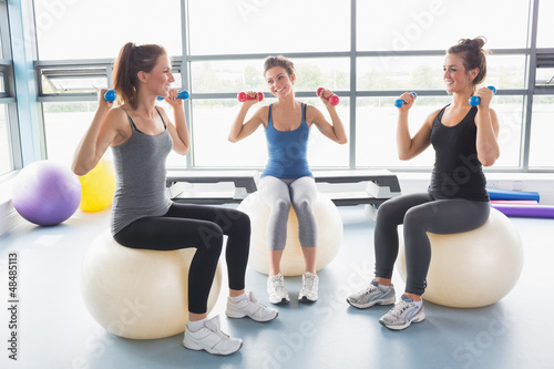 Photo: Three women lifting weights on exercise balls Three women lifting weights on exercise balls