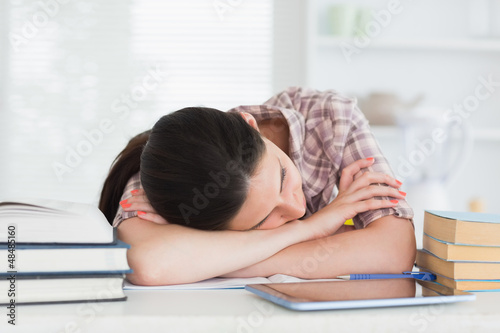 Photo: Brunette leaning on the table next to books Brunette leaning on the table next to books