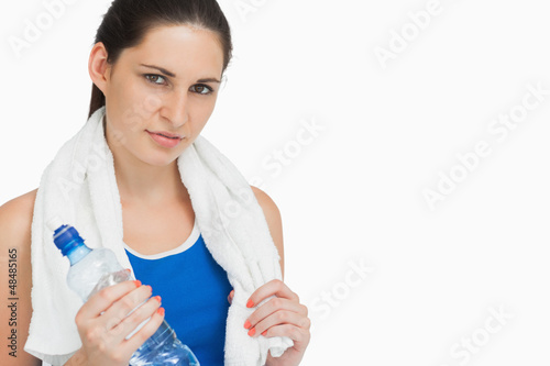 Photo: Brunette in sportswear with a towel and a bottle Brunette in sportswear with a towel and a bottle