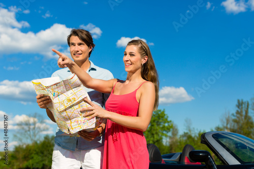 Photo: Young couple with cabriolet in summer on day trip Young couple with cabriolet in summer on day trip