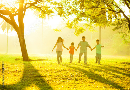 Photo: Asian family holding hands running Asian family holding hands running