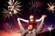 father and daughter looking fireworks in the evening sky