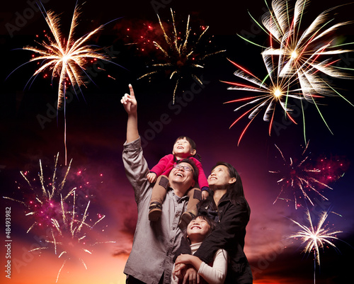 Photo: happy family looking fireworks in the evening sky happy family looking fireworks in the evening sky