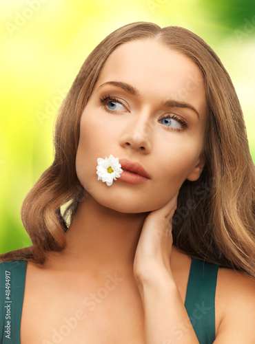 Photo: woman with camomile in mouth woman with camomile in mouth