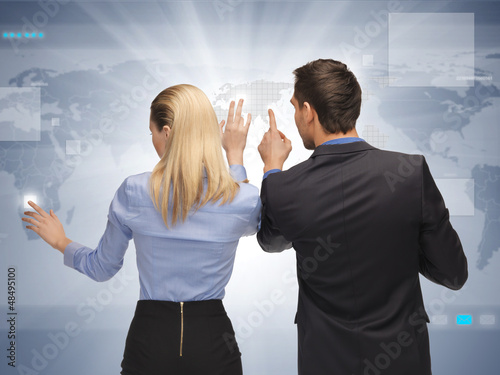 Photo: man and woman working with virtual touch screens man and woman working with virtual touch screens