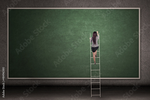 Photo: Businesswoman climbing ladder Businesswoman climbing ladder