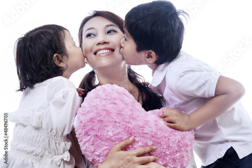 Photo: Happy mother kissed by children - isolated Happy mother kissed by children - isolated