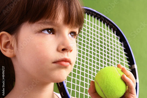 Photo: Portrait of a young girl with a tennis racket. Portrait of a young girl with a tennis racket.
