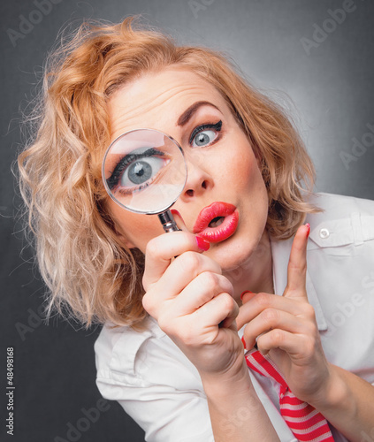 Photo: Woman with magnifier, close-up expressive face of a funny woman Woman with magnifier, close-up expressive face of a funny woman