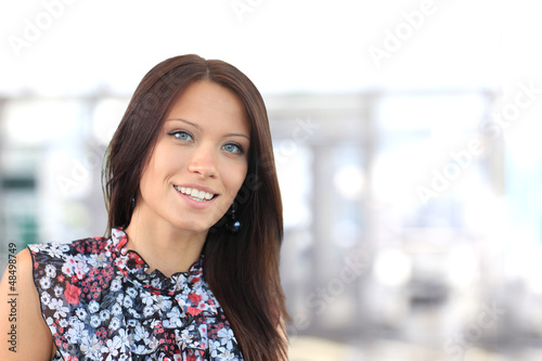 Photo: A portrait of a young business woman in an office A portrait of a young business woman in an office