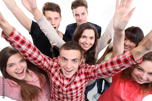 Photo: Excited group of people with arms up isolated over a white Excited group of people with arms up isolated over a white