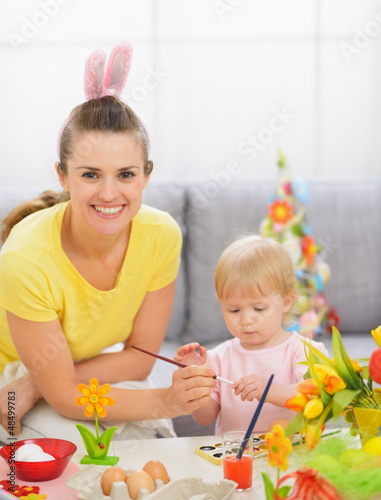 Photo: Happy mother and baby painting on Easter eggs Happy mother and baby painting on Easter eggs