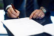 Close up of businessman signing a contract.
