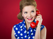 50s style housewife gossiping in a red vintage phone
