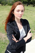 Beautiful young woman standing outside with hands folded