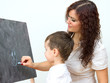 Woman and little boy drawing on board