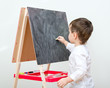 Little boy drawing on blackboard