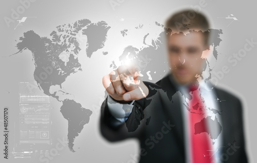 Photo: Businessman looking at a digital world map Businessman looking at a digital world map