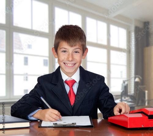 Photo: Little businessman in the office Little businessman in the office