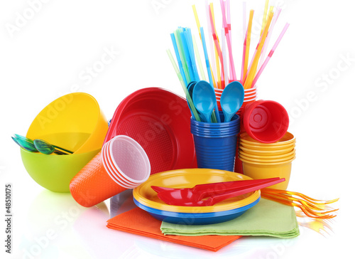 Photo: Bright plastic tableware and napkins isolated on white Bright plastic tableware and napkins isolated on white