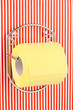 Roll of toilet paper on  holder fixed to pinstriped wall
