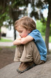 Thoughtful boy sitting on rock