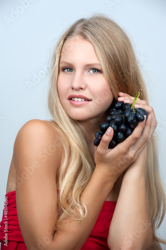 Photo: Young girl holding a bunch of grapes Young girl holding a bunch of grapes