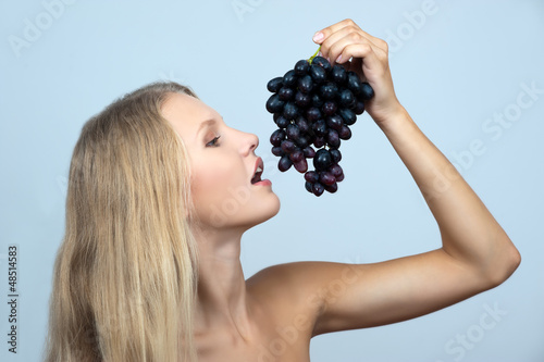Photo: Young girl holding a bunch of grapes Young girl holding a bunch of grapes