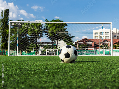 Photo: soccer ball on green grass in front of goal net soccer ball on green grass in front of goal net
