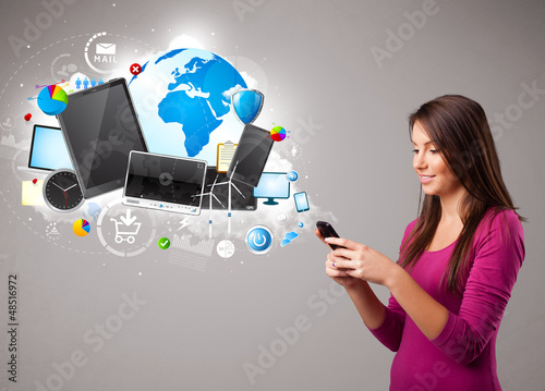 Photo: young woman standing and browsing on her phone young woman standing and browsing on her phone
