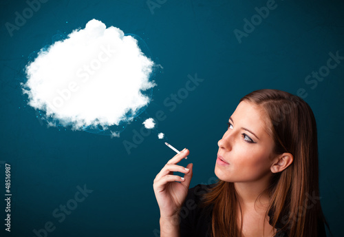 Photo: Young woman smoking unhealthy cigarette with dense smoke Young woman smoking unhealthy cigarette with dense smoke