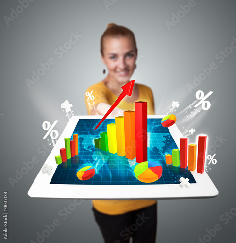 Photo: Young woman holding tablet with colorful graphs and diagrams Young woman holding tablet with colorful graphs and diagrams