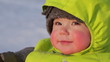 Baby smiling and playing with mother in the snow (baby close-up)