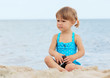 Foto: little girl playing on the sea shore little girl playing on the sea shore