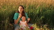 Mother with baby blows soap bubbles.