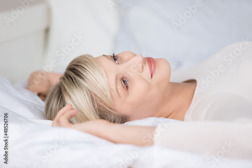 Photo: attraktive frau liegt entspannt auf dem bett attraktive frau liegt entspannt auf dem bett