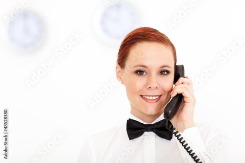 Photo: pretty young receptionist working at hotel reception pretty young receptionist working at hotel reception